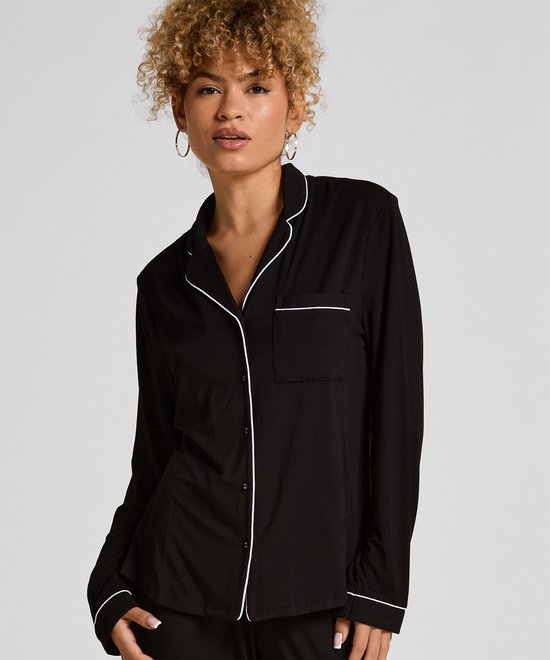 Model met lang gebreid nachthemd in zwart met witte biezen en kraag.