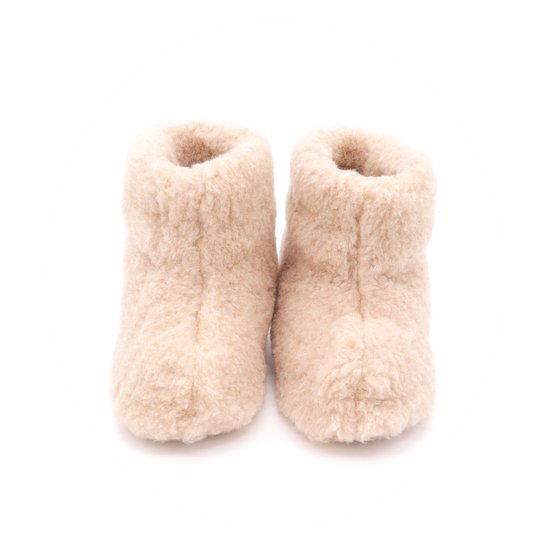 Hoge beige wollen sloffen met bruine zolen, van voren gezien.