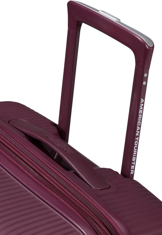 Uitschuifbaar handvat van een bordeauxrode koffer met American Tourister logo.