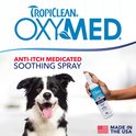 Een lachende Border Collie met een flesje OxyMed Anti-Itch Medicated Soothing Spray in een hand.