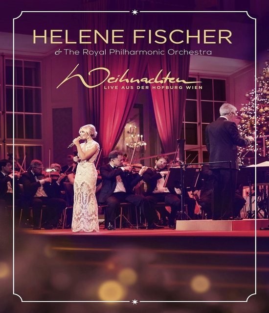 Helene Fischer zingt met microfoon, in witte jurk, met orkest op podium in Hofburg Wien.