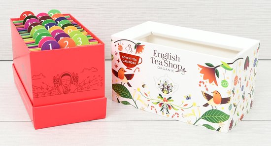 Engelse theeshop adventskalender met een rode doos vol genummerde theezakjes naast het witte deksel met kerstmotieven.