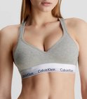 Model in grijze Calvin Klein bralette met V-hals en wit logo-elastiek.