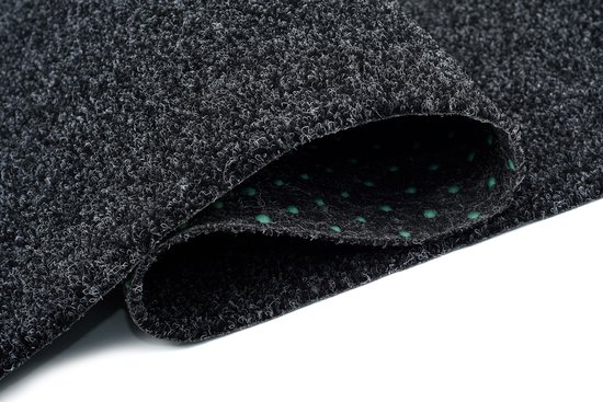 Tapis gris foncé enroulé avec texture visible et picots verts.