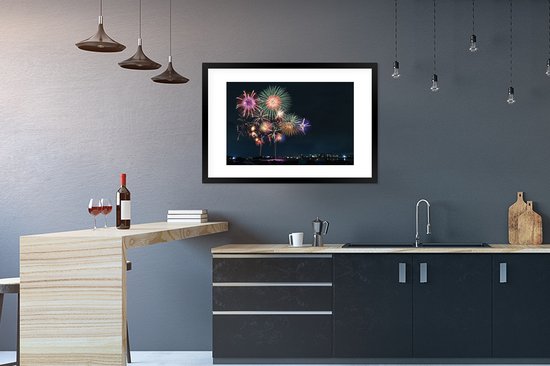 Photo en cadre - Une image de feu d'artifice dans une ville pendant le nieuw An Cadre photo noir avec passe-partout blanc grand 90x60 cm - Affiche sous cadre (Décoration murale salon / chambre)