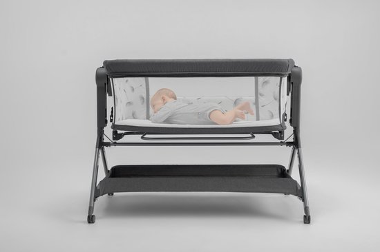 Grijze wieg met baby en paardenbloemenprint op de zijkanten.