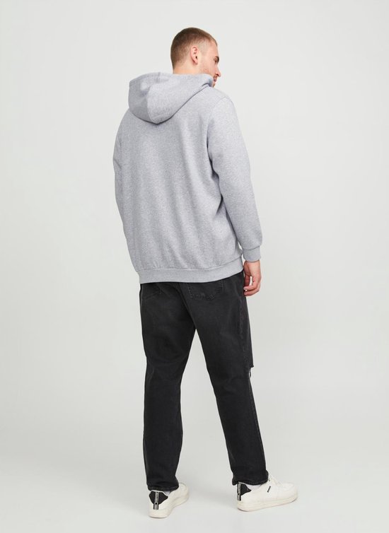 Achterkant van een man in grijze hoodie, donker T-shirt en zwarte jeans.