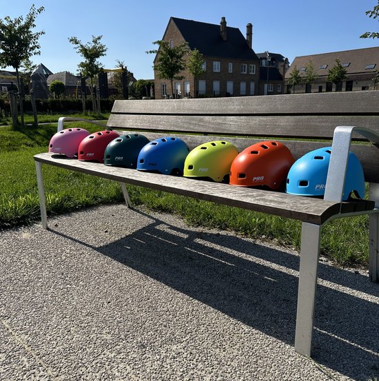 Sept casques PRO SPORT LIGHTS colorés sur un banc en bois: rose, rouge, vert, bleu, jaune, orange, bleu clair.