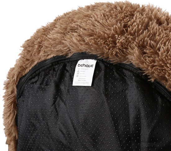 Onderkant van een bruine, fluffy hondenmand met een waslabel en antislip nopjes op de zwarte bodem.