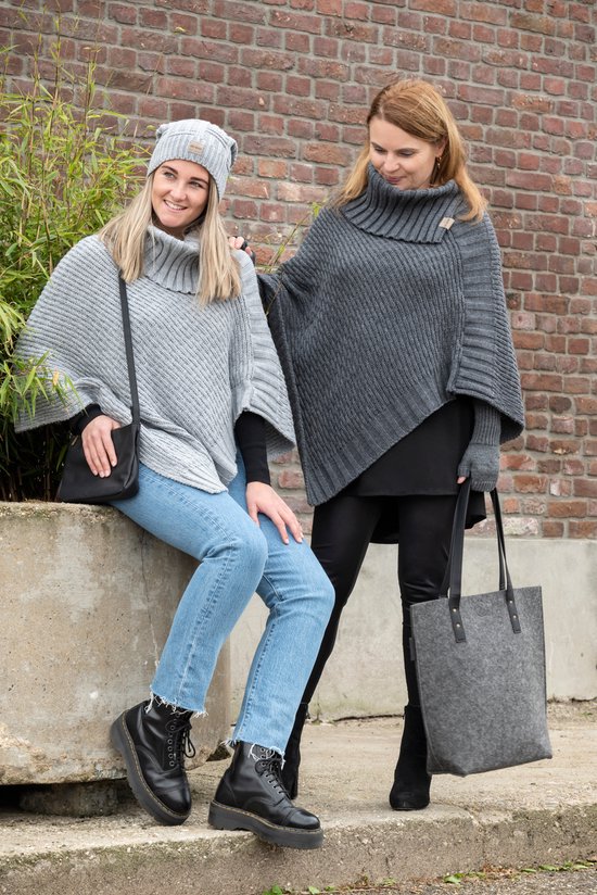 Twee vrouwen met gebreide poncho's; een grijze aan de linkerkant zittend, en een donkergrijs aan de rechterkant staand.