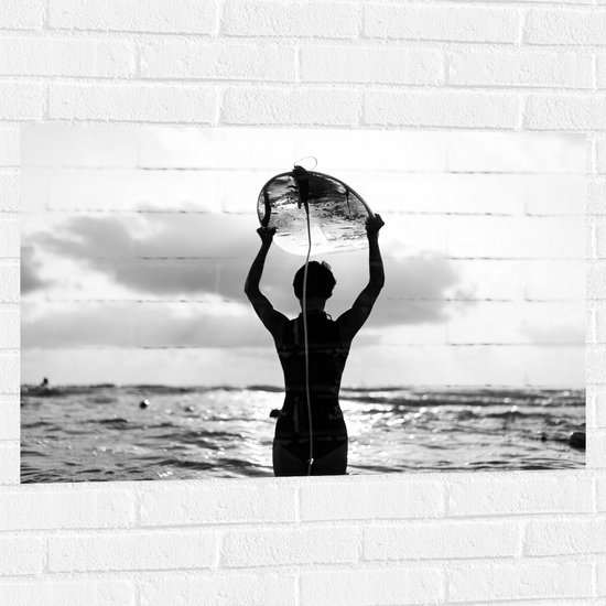 Muursticker - Achteraanzicht van Persoon met Surfplank boven het Hoofd (Zwart-wit) - 90x60 cm Foto op Muursticker