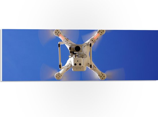 PVC Schuimplaat- Onderaanzicht van Vliegende Drone onder Blauwe Lucht - 60x20 cm Foto op PVC Schuimplaat