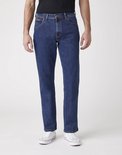 Blauwe Wrangler jeans, regular fit, gedragen met zwart T-shirt en witte sneakers.
