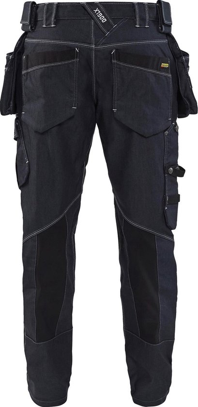 Achterkant van een donkerblauwe werkbroek met gereedschapszakken, logo en witte stiksels.