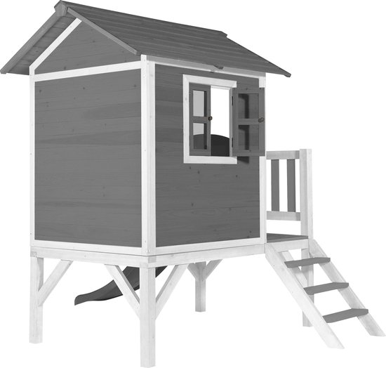Grijs houten speelhuis op palen met witte randen, een veranda, trap en een schuif aan de zijkant.