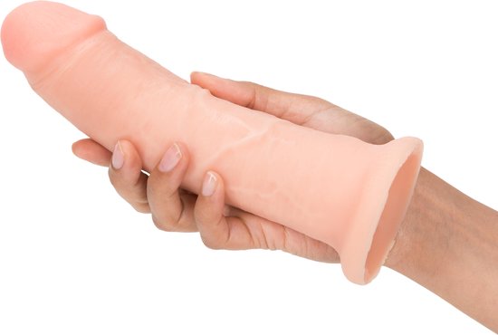 Un gode ceinture beige, à base large en forme de disque, tenu dans des mains. Le gode présente des veines réalistes.