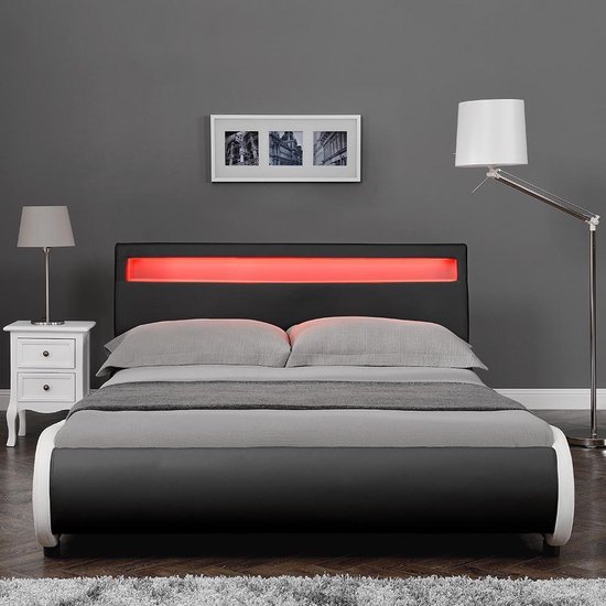 Cadre de lit noir avec tête de lit courbée, éclairage LED rouge, accents argentés et linge de lit gris dans une chambre.