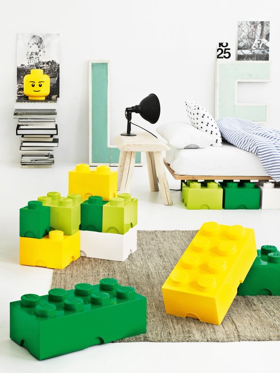 Kinderkamer met LEGO opbergdozen in geel, groen en wit op een kleed.
