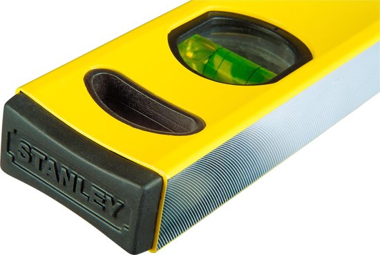 Detail van de gele Stanley waterpas met zwarte uiteinden en bubbelnivelleerder.