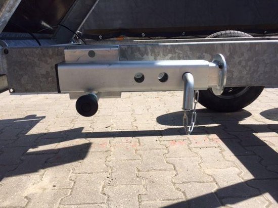 Zilverkleurige kantelbare steunpoot met ketting, bevestigd aan de zijkant van een aanhangwagen.