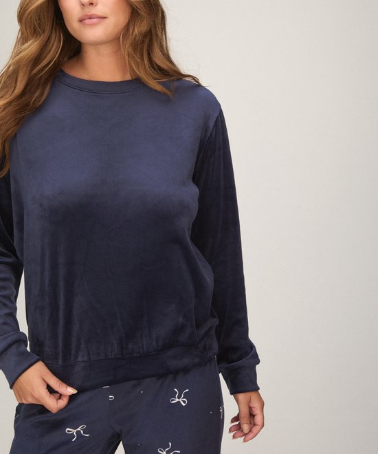 Donkerblauwe pyjamaset van velours met strikje print op de broek.
