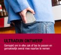 Een hand in een blauwe trui stopt een dunne, grijze magnetische powerbank in een spijkerbroekzak.