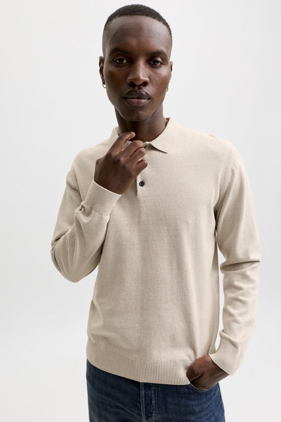 Man met beige gebreide polo en spijkerbroek, zijaanzicht.