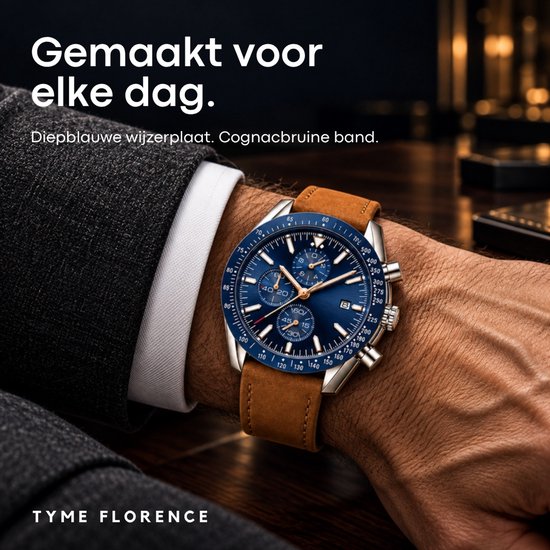 TYME Florence horloge met diepblauwe wijzerplaat en cognacbruine band, gedragen om een pols in een colbert.