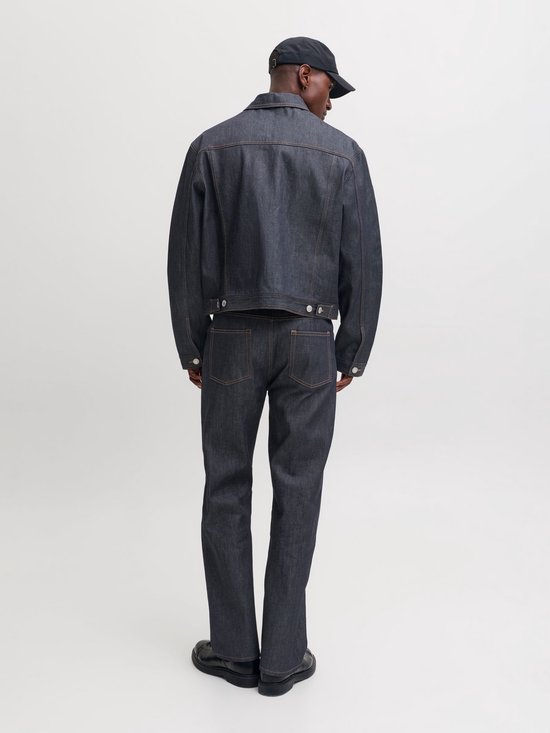 Model van achteren gezien in een donkerblauw denim jack en bijpassende straight fit jeans.