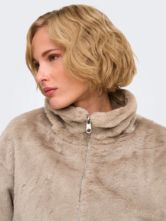 Detailopname van de zilverkleurige ritssluiting met ONLY-merklogo op een beige imitatiebont jack.