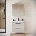 Badkamermeubelset met hangende wastafelkast in beige en spiegelkast, geplaatst in een badkamer met douche.