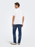 Achterzijde van een model met een wit T-shirt en blauwe jeans, gecombineerd met beige en witte sneakers.