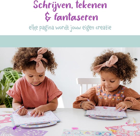 Twee meisjes met krullend haar en strikjes in het haar tekenen geconcentreerd in hun unicorn doeboek aan een witte tafel.