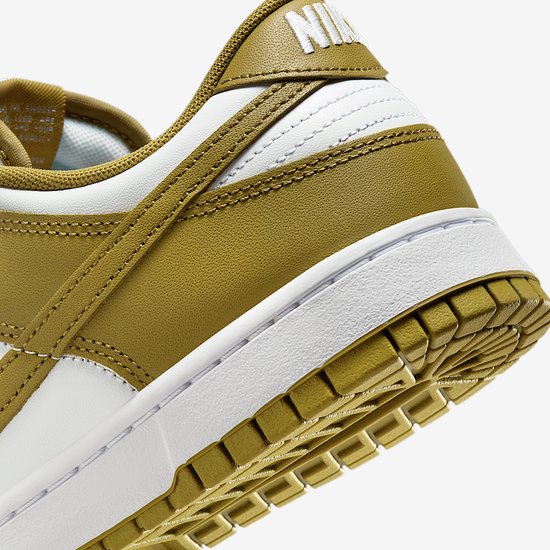 Close-up van de gestructureerde olijfgroene hiel en witte zool van de sneaker.