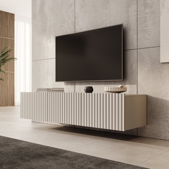 Beige, zwevend TV-meubel Pepinos van 150 cm met een verticaal geribbeld front tegen een betonnen muur.