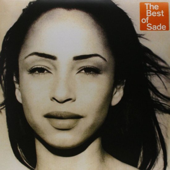 Gros plan de Sade aux cheveux sombres regardant l'objectif. En haut à droite, le texte 'The Best of Sade'.