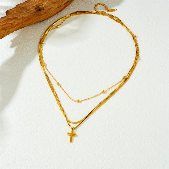 Gouden multistraks ketting met een hanger in kruisvorm.