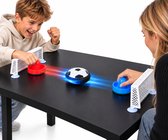 Twee kinderen spelen airhockey met een voetbal als puck. Rood en blauw gekleurde pucks met lichteffecten.