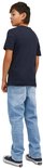 Jongens lichtblauwe jeans en donkerblauw t-shirt, van achteren gezien.
