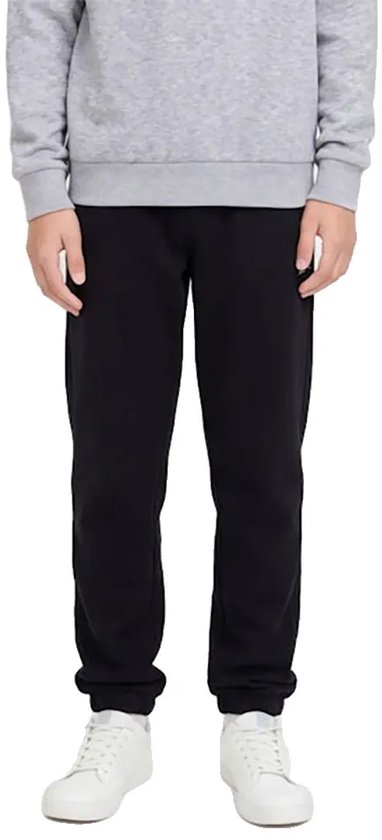 Jongen draagt een zwarte joggingbroek met grijze trui en witte sneakers.