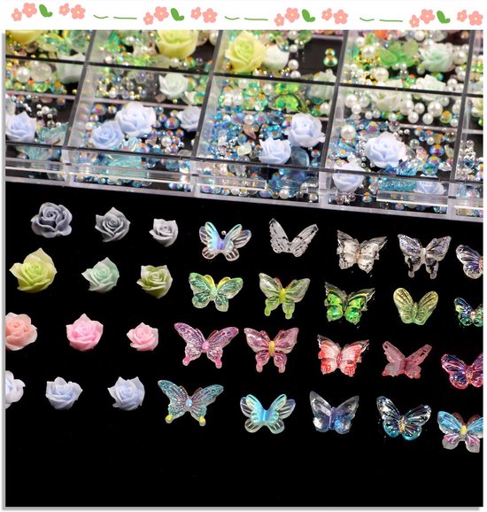 Losse nail art decoraties op een zwarte achtergrond: kleine rozen in grijs, geel, roze en blauw, diverse vlinders en strass steentjes.