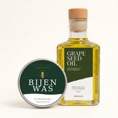 Fles druivenpitolie en blikje bijenwas van TheWootz voor houten snijplanken, op een lichte achtergrond.