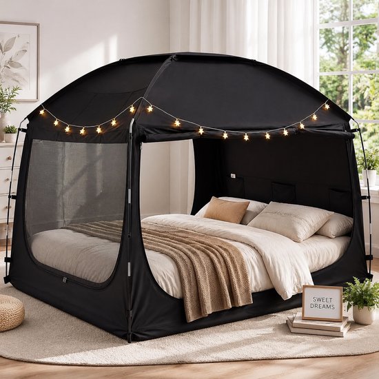 Tente de lit noire avec guirlande lumineuse en forme d'étoile, avec un lit à l'intérieur.
