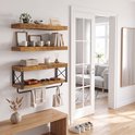 Houten wandplanken met metalen frame, met boeken, handdoeken en toiletrollen.