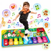 Jongen springt op een muziekmat met pianotoetsen, versierd met dieren en muzieknoten.