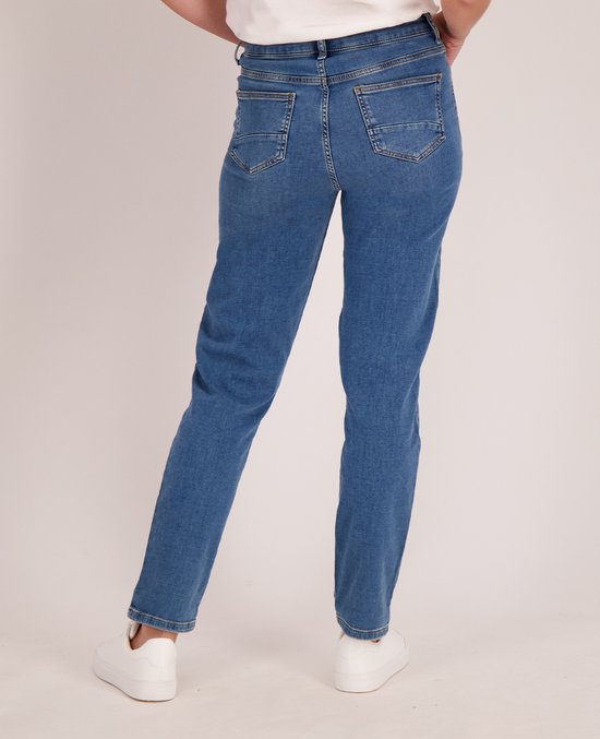 Achterkant van een model in een blauwe spijkerbroek met omgeslagen broekspijpen.