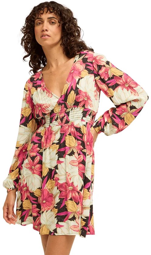 Model van voren, draagt een veelkleurige jurk met lange mouwen, V-hals en bloemenprint, gerimpelde taille.