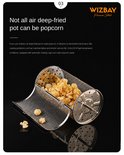 Verguld metalen mandje gevuld met popcorn, met enkele korrels ernaast, in een airfryer.