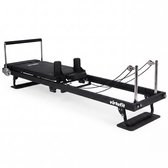 Zwarte pilates reformer met wielen en metalen onderdelen, op witte achtergrond.