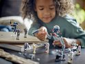 Een meisje speelt met LEGO Star Wars-onderdelen: clone troopers, battle droids, speeder en tri-droid op tafel.